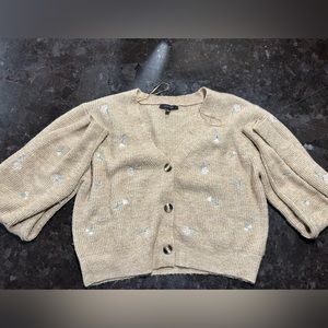 This is a tan cropped sweater with pink flowers and long sleeves. From Love Tree